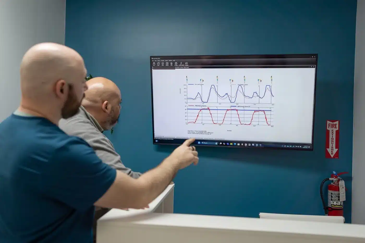 Dr. Bobby Koser, DC, chiropractic physician, reviewing functional assessment results on screen with a patient at HealthSpine Chiropractic in Carrollwood, Tampa.