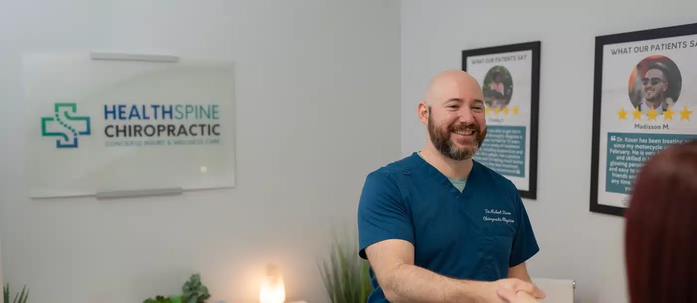 Dr. Bobby Koser, DC, chiropractic physician, talking with a patient in the consultation room at HealthSpine Chiropractic in Carrollwood, Tampa.