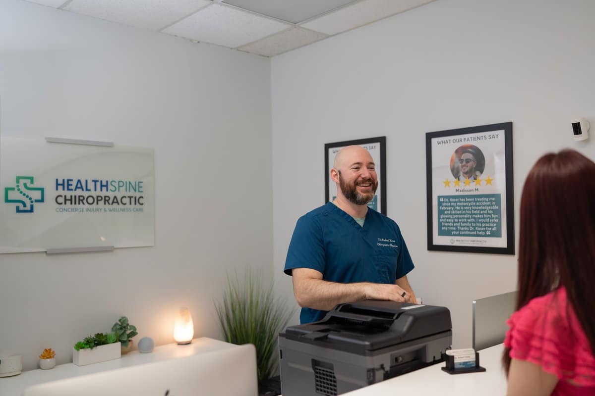 Dr. Bobby Koser, DC, chiropractic physician, at the front desk of HealthSpine Chiropractic in Carrollwood, Tampa