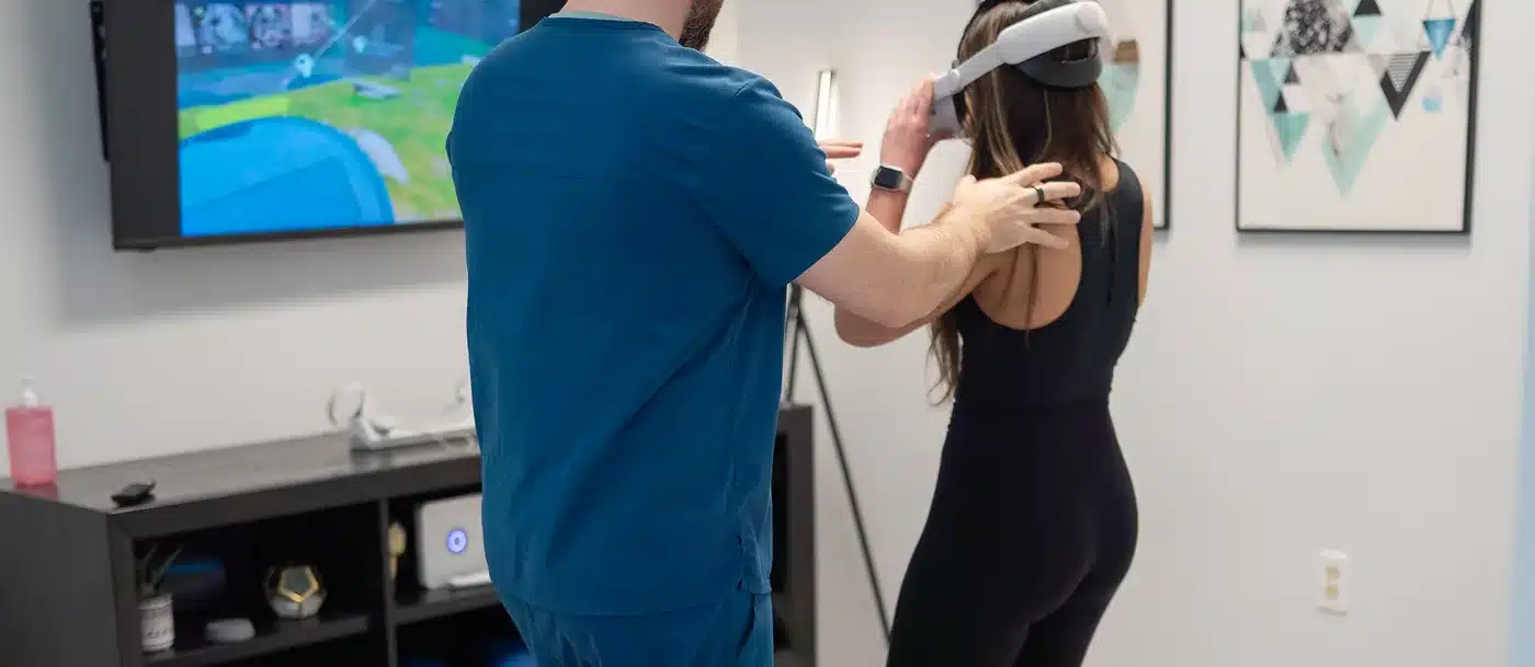 Dr. Bobby Koser, DC, chiropractic physician, assessing a standing patient’s spine and posture at HealthSpine Chiropractic in Carrollwood, Tampa.