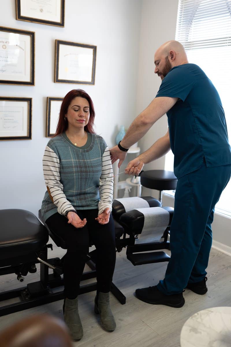 Dr. Bobby Koser, DC, chiropractic physician, testing a patient&rsquo;s shoulder range of motion at HealthSpine Chiropractic in Carrollwood, Tampa.