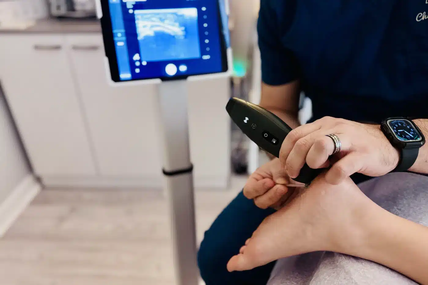 Dr. Bobby Koser, DC, chiropractic physician, examining a patient's foot and ankle with diagnostic ultrasound at HealthSpine Chiropractic in Carrollwood, Tampa.